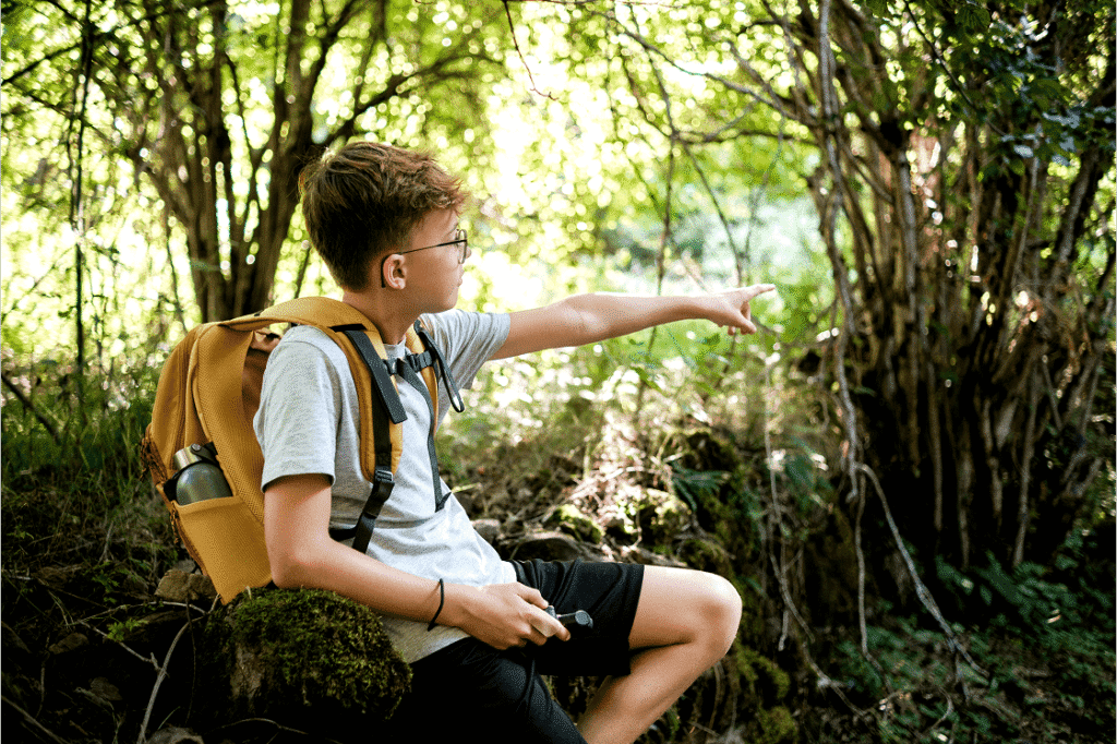 A young boy on a hike points out a cool tree system.