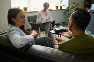 Adults dealing with emotional trauma in therapy.