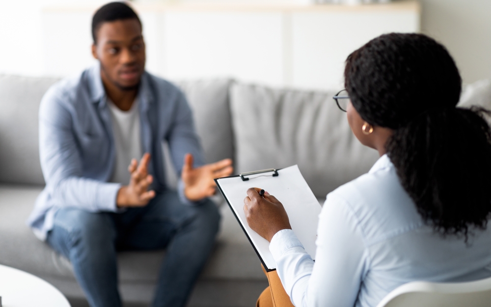 Patient sitting on a couch across from his provider. Questions to Ask Your Psychiatric Provider About Your Medication